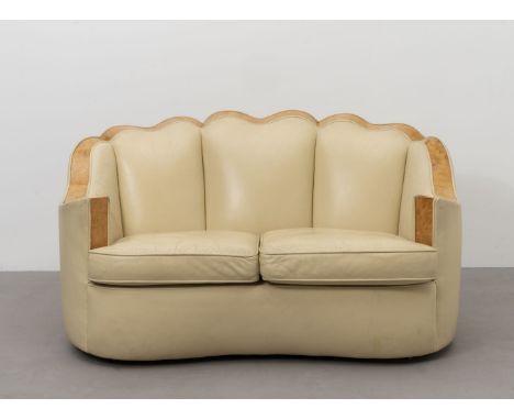 Art DecoThree-piece suite, circa 1930Cream leather upholstered sofa with scalloped back and the two tub chairs framed on the 