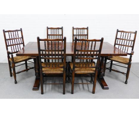 Modern dark oak dining suite comprising a trencher planked top table and set of six chairs, with spindle backs, rush seats an