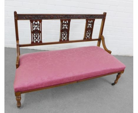 Mahogany framed two seater hall settee, with a foliate carved top rail, vertical splat back and pink upholstered seat, on tur