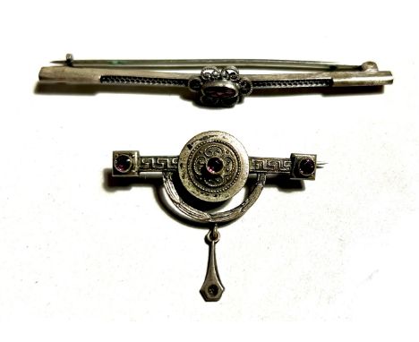Zwei Jugendstil-Broschen:1. Lange Brosche, mittig lilafarbener Stein, dieser floral dekoriert, durchbrochen gearbeitet, Länge