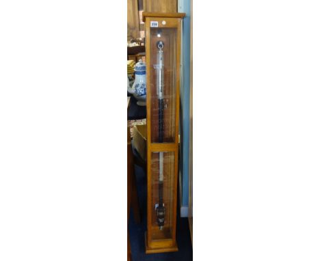 A stick barometer in oak case by Philip &amp; Harris.
