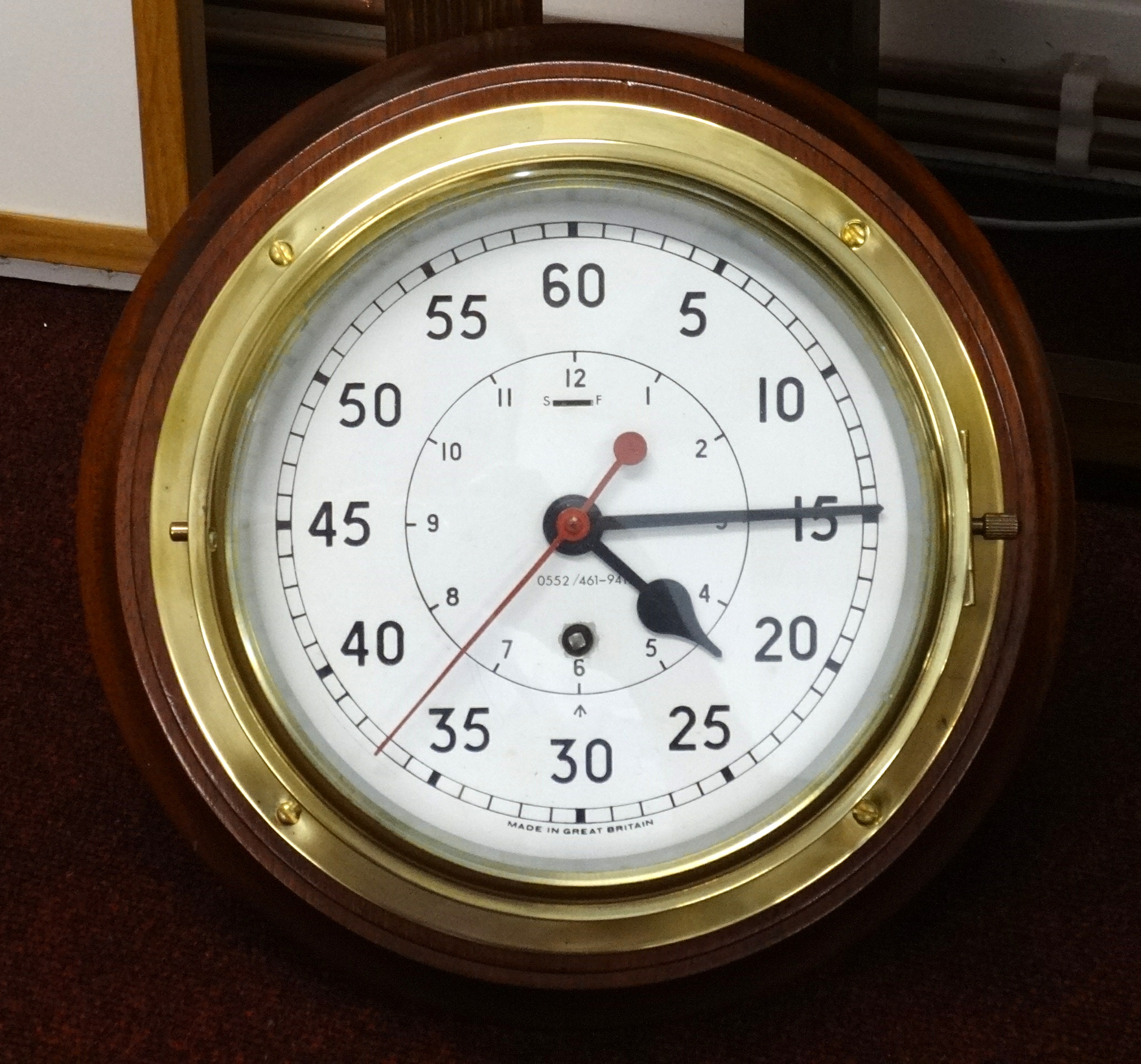 A brass ships clock, on wood mount, running, with key, diameter approx