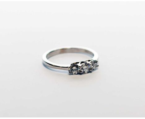 A three stone diamond ring, the brilliant cut diamonds claw set in white metal to white metal shank, stamped 'PT950', ring si