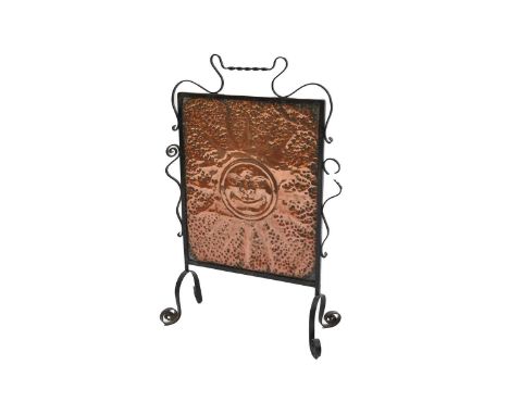 A wrought iron and copper fire screen, mid 20th century, of rectangular form, the hammered copper embossed with a sunburst wi
