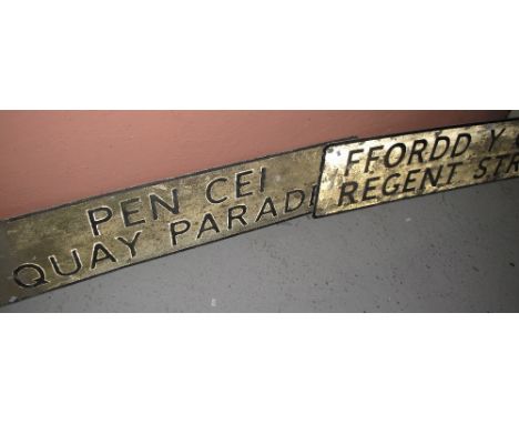 Two Welsh language metal street signs, 'Fordd Y Gaer' (Regent Street) and 'Pen Cei' (Quay Parade). (2)