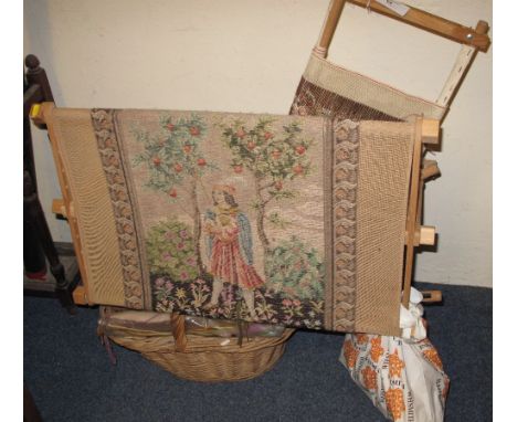 A tapestry frame (floor standing), together with another smaller frame and a basket of tapestry wools and patterns.