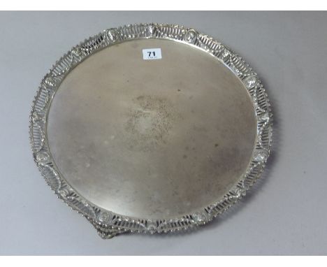 Silver circular tray with cast border, pierced and embossed with poles, masks and swags, on similar feet, by R. Rugg, 1775, p