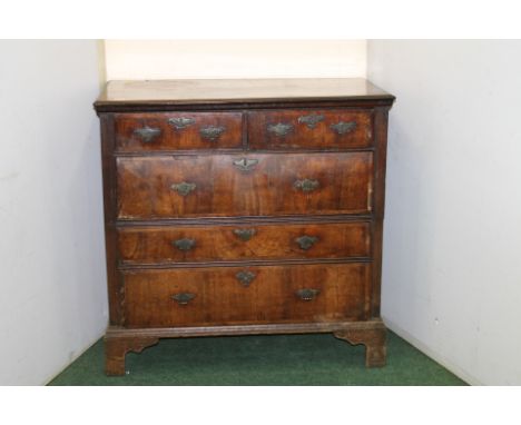 Early 18th century cross-banded walnut chest of two short and three graduated long drawers, stamped brass handles on bracket 