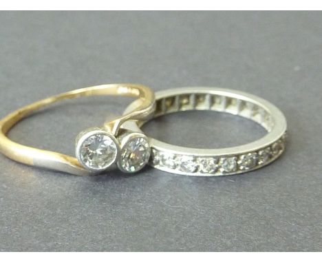 Diamond two stone crossover ring with collet set brilliants and an eternity ring with mixed cut brilliants (2).