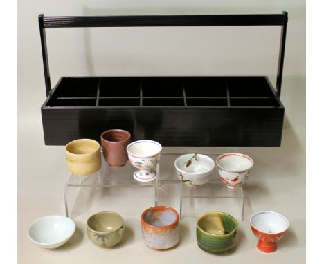 Modern Japanese set of ten specimen ceramic tea bowls contained in a black lacquer carrying tray, each tea bowl representing 