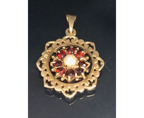 9ct Gold Pendant set with a central Pearl and surrounded by Garnet gemstones approx 20mm in diameter and 2.2g