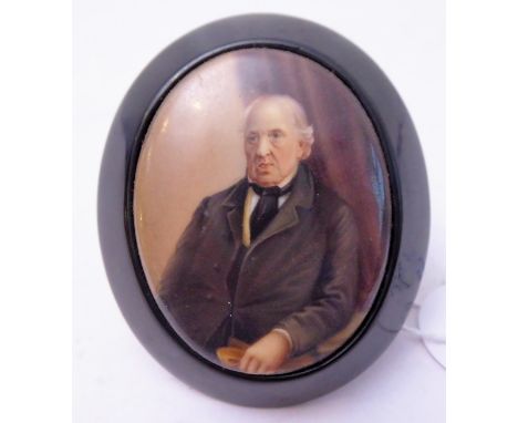 A 19th century ebonised framed oval portrait miniature brooch/pendant; central oval porcelain insert painted with a half-leng