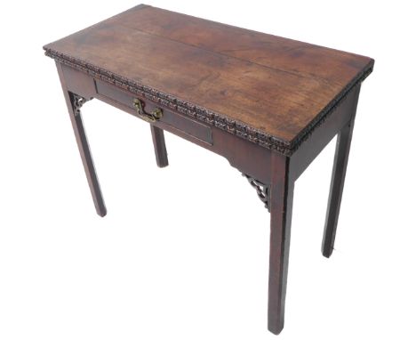 An 18th century Chippendale period foldover-top mahogany card table; the moulded edge carved with stylised ornament above a s