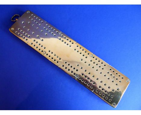 A 19th century polished brass fronted and oak backed cribbage board with suspension loop for wall hanging (32.75cm)