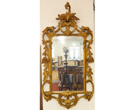 A Chippendale-style carved giltwood wall-hanging looking glass (mid-20th century) - the pierced pediment with leaves, C-scrol