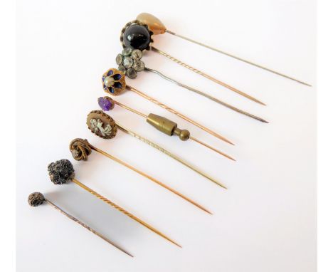 A small collection of nine stick pins including an old brilliant-cut example within a textured double wirework surround, a 19
