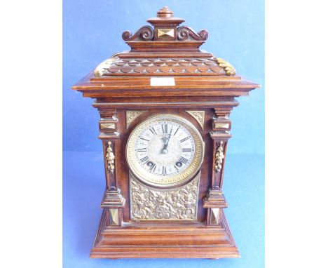 A late 19th century walnut gilt-metal-mounted eight-day mantle clock; the finely carved pediment with a scale-style front bor