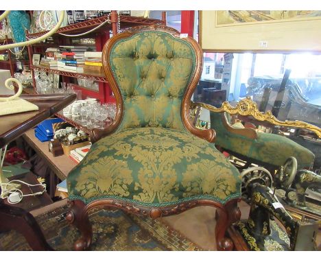 A mid Victorian carved walnut button-back armchair, the serpentine front seat on scroll foot cabriole legs