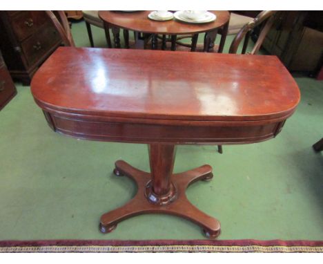 A William IV mahogany bow front card table, the revolving top with release button to verso on chamfered tapering column and p