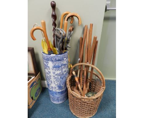A collection of umbrellas, shooting sticks and a 20th century tourist ware walking stick along with a collection of croquet m