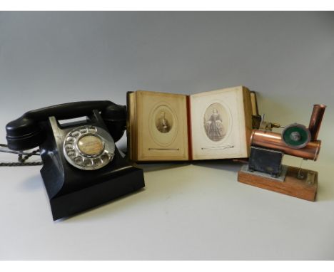 A small copper and brass stationery engine titled 'Dorothy' to the oak base, a Victorian photograph album, a Bakelite telepho