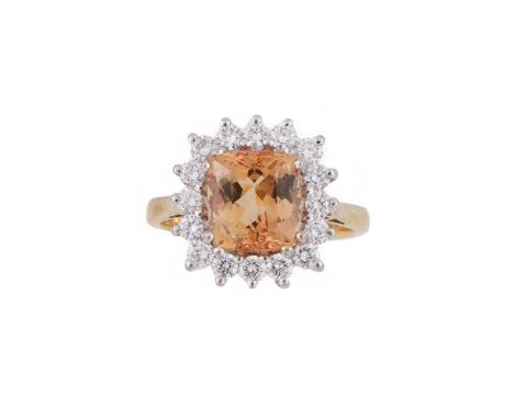 A TOPAZ AND DIAMOND CLUSTER RING  LONDON 1992  The mixed cut topaz estimated to weigh 3.26 carats claw set within a surround 