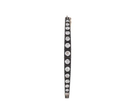 AN EARLY 20TH CENTURY DIAMOND HINGED BANGLE  The graduated old European cut diamonds in squared silver settings, approximatel