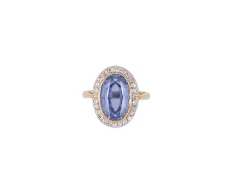 A SAPPHIRE AND DIAMOND CLUSTER RING  BIRMINGHAM 1993  The oval cut sapphire estimated to weigh 6.70 carats within a surround 