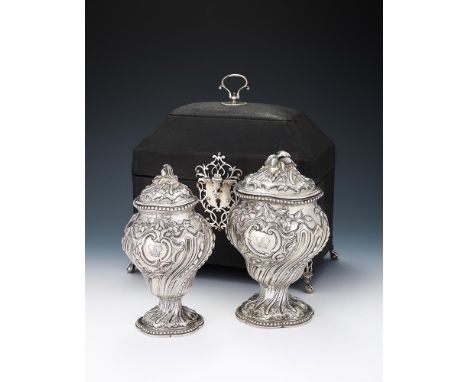 TWO CASED GEORGE III SILVER TEA CADDIES FRANCIS BUTTY & NICHOLAS DUMEE, LONDON 1766 With foliate finials to the chased domed 