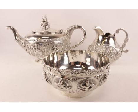 Indian silver three piece tea service by Tarachund Parsram, Bombay the tea pot chased with band of deities riding an various 