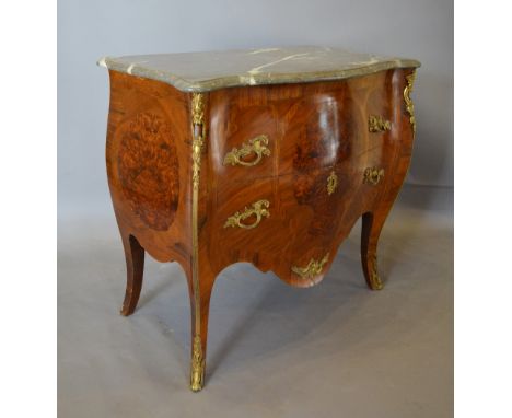 A Louis XVI Style Bombe Commode with a rouge marble serpentine top above two drawers with brass handles and escutcheons raise