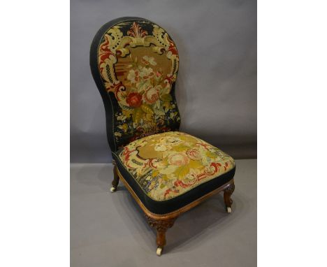 A Victorian Walnut Large Chair, the shaped tapestry upholstered back above a similar seat raised upon carved cabriole legs wi