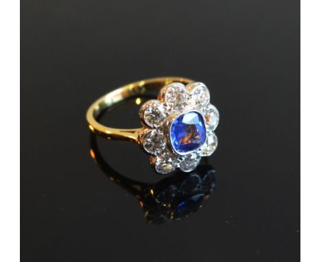 An 18ct. Yellow Gold Sapphire and Diamond Cluster Ring with a central sapphire surrounded by diamonds approximately 1.35 / 1.