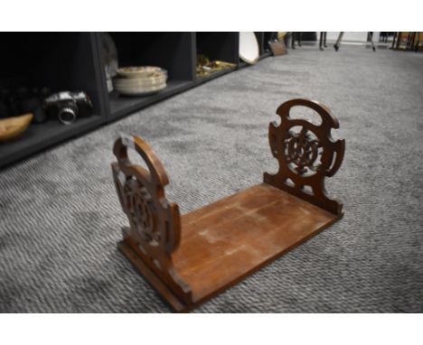 A vintage book shelf or rack having gothic fret work ends