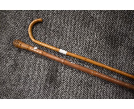 A bent wood walking stick and a similar bamboo cane