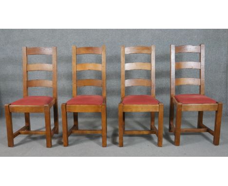 A set of four continental hardwood ladder back dining chairs, the drop-in seat upholstered in burgundy fabric, on square sect