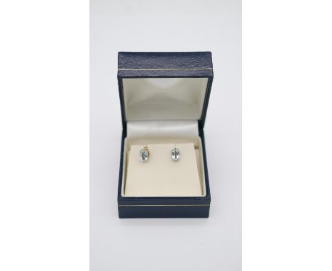 A boxed pair of aquamarine and 9ct gold stud earrings, each set with an oval mixed cut aquamarine, the two earrings with a co