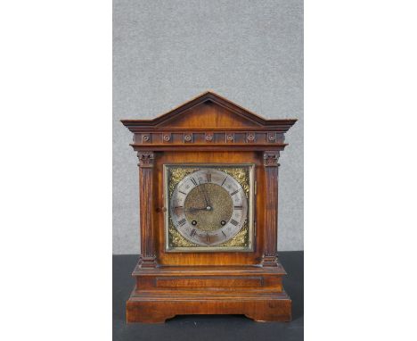 A Victorian architectural mantel clock, with an arched cornice over a frieze of roundels, above a pair of Corinthian fluted c