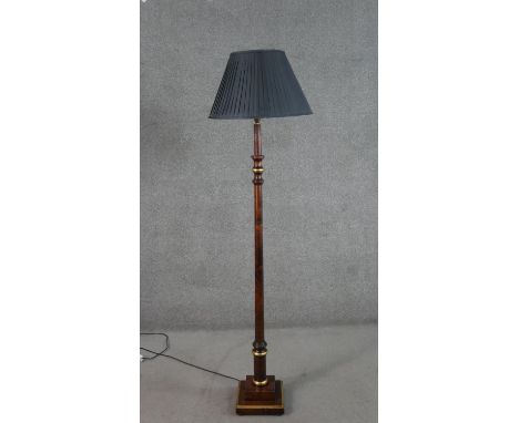 A contemporary turned fruitwood and parcel gilt standard lamp, with a pleated shade, on a square section step down base. H.15