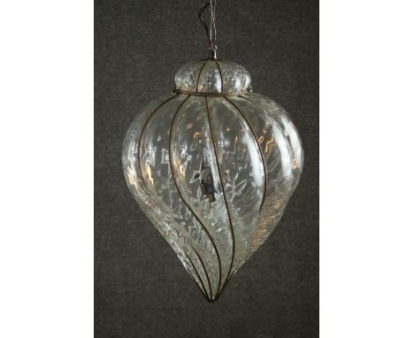 A clear wrythen glass ceiling light, in an iron wire frame, of bulbous form with a pointed tip. H.70 Dia.23cm. 