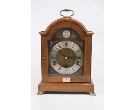 An 18th century style walnut cased bracket clock having a brass arched dial with silvered chapter ring, having Roman numerals