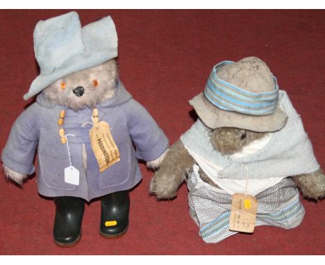A Paddington Bear soft toy in white mohair with orange glass eyes, in blue felt hat, blue felt duffle coat, and green Dunlop 