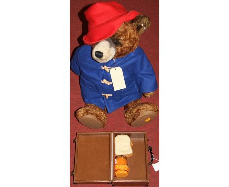 A large Steiff Paddington Bear in brown mohair with red hat, blue duffle coat with button and white label to ear No. 664960 w