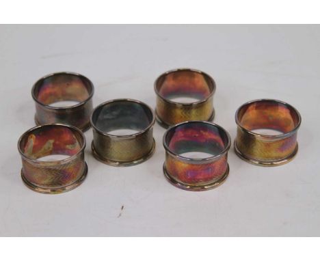 A set of six George V silver napkin rings, each with engine turned decoration and vacant cartouche, 2.3oz 