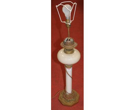 A Victorian oil lamp, having an opalescent glass font on a milk glass column and embossed brass base, later converted for ele