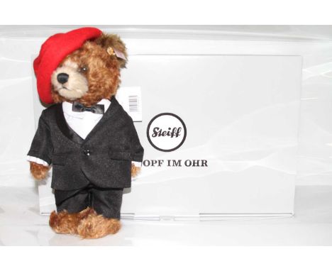 A Steiff mohair bear in red hat and black suit label with button to ear and white label number 690235 with further card tag, 