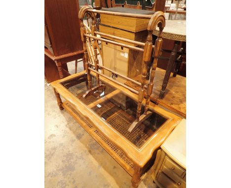 Large smoked glass top coffee table with wicker under shelf and a stained pine towel rack