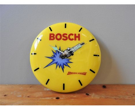 BOSCH BRANDED PROMOTIONAL WALL CLOCK  c. 1980s, in plastic, yellow with black baton hour markers and Bosch logo in red. 
