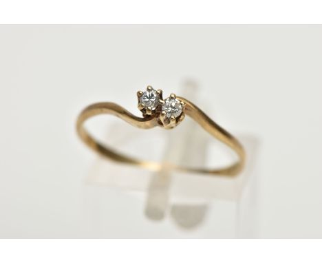 A 9CT GOLD DIAMOND RING, of a cross over design, set with two claw set round brilliant cut diamonds, tapered shoulders to a t