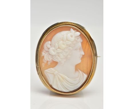 A YELLOW METAL CAMEO BROOCH, of an oval from, depicting a lady in profile, collet mount with a rope twist surround, fitted wi